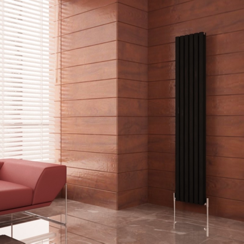 Tall silver vertical radiators mounted close together on a wall. They have narrow vertical rectangular panels with sleek edges and multiple horizontal fins behind for heat transfer and a modern, minimalist look. The radiators have an elegant, simple design that complements the room with their height and vertical orientation emphasised.